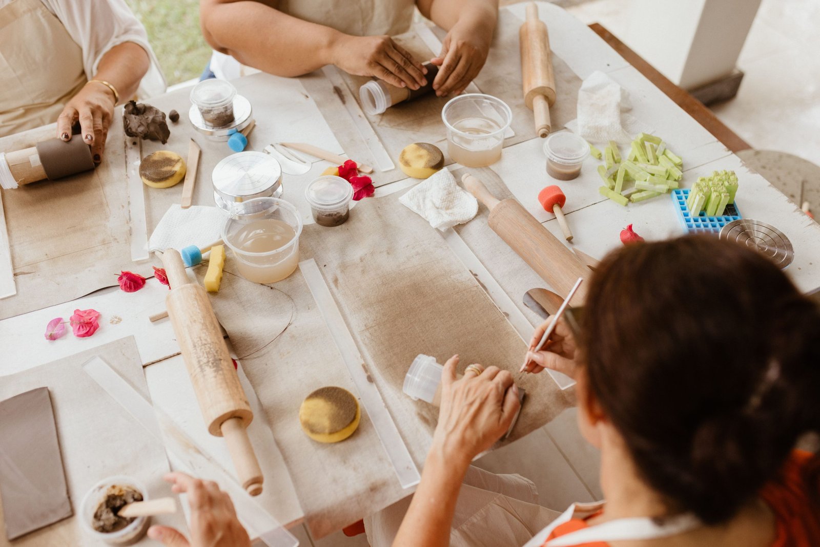 Devenir artisan Table d’atelier vue de dessus, mains dans la matière